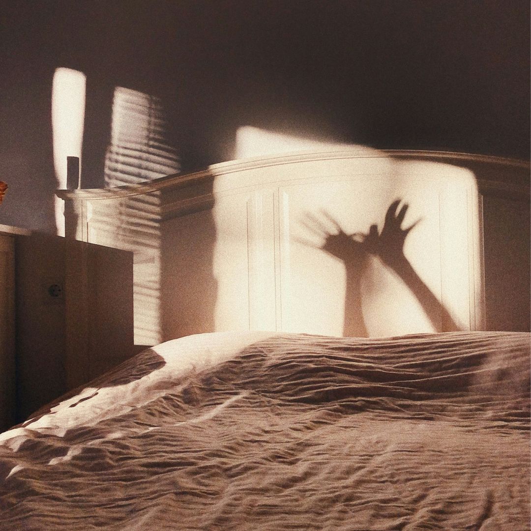 Playful hand shadows on a bed head
